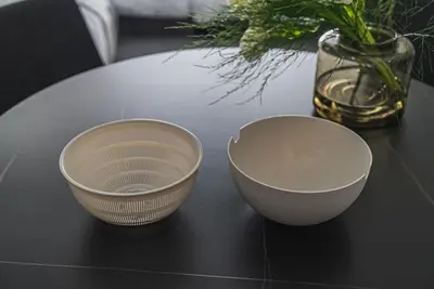two bowls sitting on a table with a vase of flowers at ERIKO HOTEL Azabujuban in Tokyo