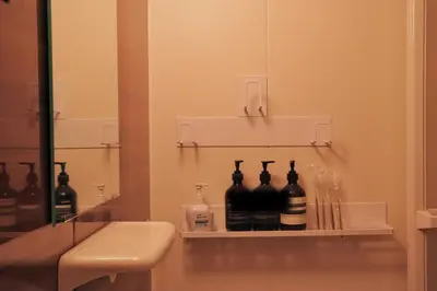 a bathroom with a shelf with bottles on it at Vibe Shibuya in Tokyo