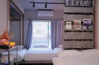 a bedroom with three beds and a window at Vibe Shibuya in Tokyo
