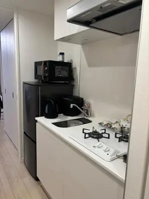 a kitchen with a stove and a black refrigerator at Yui Rin Asakusa 902 in Tokyo