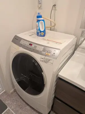 a washing machine with a bottle of detergent on top of it at \u65b0\u5bbf\u306e\u4e00\u8ed2\u5bb6 \u725b\u8fbc\u67f3\u753a\u99c5\u5f92\u6b694\u5206 70\u5e73\u7c73 3\u5bdd\u5ba4 5\u30d9\u30c3\u30c9 7\u4eba\u307e\u3067\u5bbf\u6cca\u53ef in Tokyo