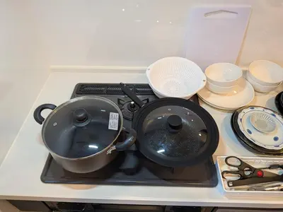 a pot sitting on top of a stove with dishes at \u65b0\u5bbf\u306e\u4e00\u8ed2\u5bb6 \u725b\u8fbc\u67f3\u753a\u99c5\u5f92\u6b694\u5206 70\u5e73\u7c73 3\u5bdd\u5ba4 5\u30d9\u30c3\u30c9 7\u4eba\u307e\u3067\u5bbf\u6cca\u53ef in Tokyo
