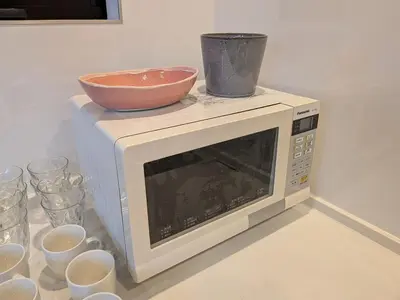 a microwave with a bowl on top of it at \u65b0\u5bbf\u306e\u4e00\u8ed2\u5bb6 \u725b\u8fbc\u67f3\u753a\u99c5\u5f92\u6b694\u5206 70\u5e73\u7c73 3\u5bdd\u5ba4 5\u30d9\u30c3\u30c9 7\u4eba\u307e\u3067\u5bbf\u6cca\u53ef in Tokyo