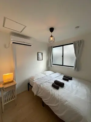 a bedroom with a large white bed with a window at \u65b0\u5bbf\u306e\u4e00\u8ed2\u5bb6 \u725b\u8fbc\u67f3\u753a\u99c5\u5f92\u6b694\u5206 70\u5e73\u7c73 3\u5bdd\u5ba4 5\u30d9\u30c3\u30c9 7\u4eba\u307e\u3067\u5bbf\u6cca\u53ef in Tokyo