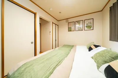 a bedroom with two beds with green and white at Ayame Inn, \u30a2\u30e4\u30e1\u30a4\u30f3, \u30b9\u30ab\u30a4\u30c4\u30ea\u30fc\u30a8\u30ea\u30a26\u5206, \u6d45\u8349\u307e\u306710\u5206, \u30ad\u30c3\u30ba\u30eb\u30fc\u30e0\u4ed8\u304d10\u540d\u69d8 in Tokyo