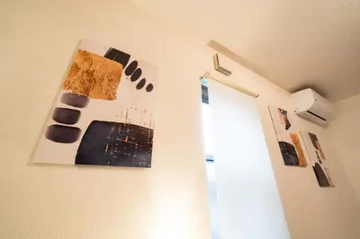 a room with paintings on the wall and a window at Ayame Inn, \u30a2\u30e4\u30e1\u30a4\u30f3, \u30b9\u30ab\u30a4\u30c4\u30ea\u30fc\u30a8\u30ea\u30a26\u5206, \u6d45\u8349\u307e\u306710\u5206, \u30ad\u30c3\u30ba\u30eb\u30fc\u30e0\u4ed8\u304d10\u540d\u69d8 in Tokyo