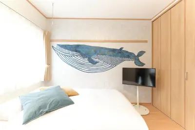 a bedroom with a fish painting on the wall at monthly \u30c9\u30df\u30fc\u30eb\u4e16\u7530\u8c37 in Tokyo