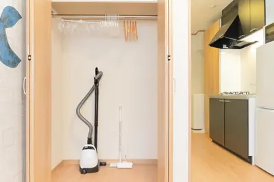 a vacuum cleaner in a kitchen next to a door at monthly \u30c9\u30df\u30fc\u30eb\u4e16\u7530\u8c37 in Tokyo