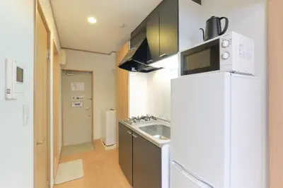 a kitchen with a white refrigerator and a sink at monthly \u30c9\u30df\u30fc\u30eb\u4e16\u7530\u8c37 in Tokyo