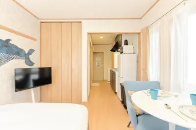 a small kitchen with a table and a refrigerator at monthly \u30c9\u30df\u30fc\u30eb\u4e16\u7530\u8c37 in Tokyo