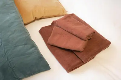 a pair of brown towels sitting next to a pillow at monthly \u30c9\u30df\u30fc\u30eb\u4e16\u7530\u8c37 in Tokyo