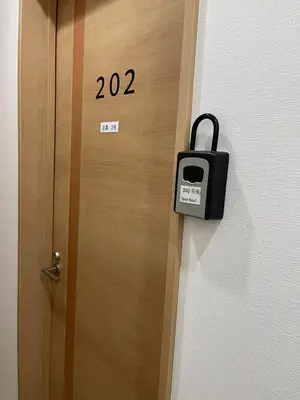 a door with a sign on it with a suitcase on it at Shin-Okubo, Shinjuku's best central location, private bathroom and toilet in Tokyo