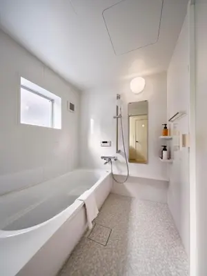 a white bathroom with a tub and a mirror at 7C's HOUSE in Tokyo