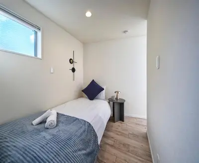 a small bedroom with a bed and a window at 7C's HOUSE in Tokyo