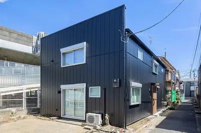 a black house with white windows on a street at 7C's HOUSE in Tokyo