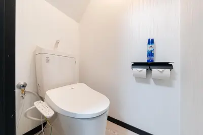 a white bathroom with a toilet and a remote control at 3-chome House Senju - Entire Private Home - Direct Access to Ueno & Asakusa in Tokyo