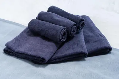 a pile of towels sitting on top of a bed at 3-chome House Senju - Entire Private Home - Direct Access to Ueno & Asakusa in Tokyo