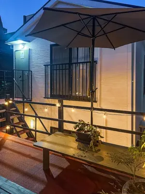a table with an umbrella on a balcony at 7-minute walk from Otsuka Station,Yamanote Line 3-person Shared garden in Tokyo