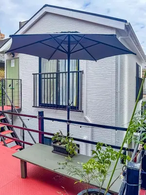 a table with a blue umbrella on a house at 7-minute walk from Otsuka Station,Yamanote Line 3-person Shared garden in Tokyo