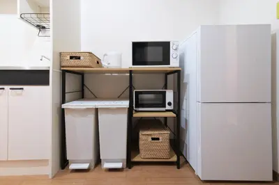 a kitchen with a desk with a computer and a refrigerator at TDR9\u5206 \u99c4\u83d3\u5b50\u3068\u30a2\u30fc\u30c8\u306e\u53ef\u611b\u3044\u30df\u30e5\u30fc\u30b8\u30a2\u30e0\u5bbf \u5922\u304c\u8a70\u307e\u3063\u305f\u5c0f\u3055\u306a\u5b9d\u7bb1 -TAMU-LAND Urayasu- in Urayasu
