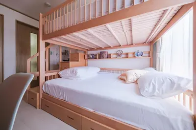 a bedroom with a bunk bed with white pillows at TDR9\u5206 \u99c4\u83d3\u5b50\u3068\u30a2\u30fc\u30c8\u306e\u53ef\u611b\u3044\u30df\u30e5\u30fc\u30b8\u30a2\u30e0\u5bbf \u5922\u304c\u8a70\u307e\u3063\u305f\u5c0f\u3055\u306a\u5b9d\u7bb1 -TAMU-LAND Urayasu- in Urayasu