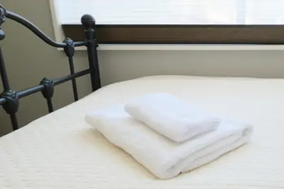 a pile of towels sitting on top of a bed at monthly HJ PLACE TAKANAWA in Tokyo