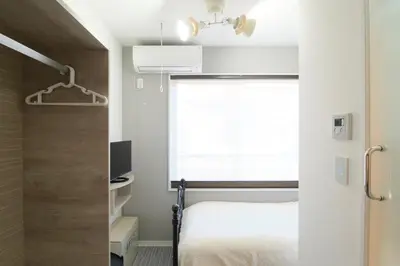 a bedroom with a bed and a window at monthly HJ PLACE TAKANAWA in Tokyo