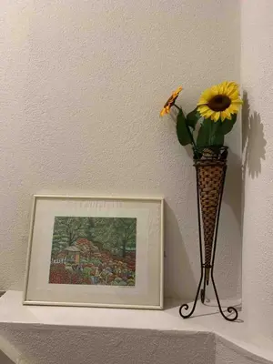 a vase with a flower on a shelf with a picture at Spacious 3BR house 6 mins to JR Koiwa Station in Tokyo