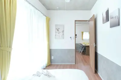 a bedroom with a bed and a sliding glass door at monthly J-ARC\u65b0\u5bbf in Tokyo