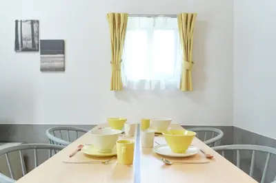 a dining room table with yellow cups and saucers at monthly J-ARC\u65b0\u5bbf in Tokyo