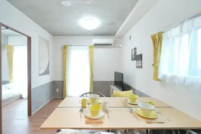 a dining room with a table with yellow cups and saucers at monthly J-ARC\u65b0\u5bbf in Tokyo