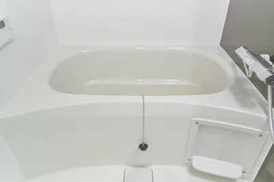 a white bath tub with a sink in a bathroom at monthly J-ARC\u65b0\u5bbf in Tokyo