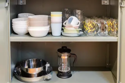 a shelf with bowls and plates and a tea kettle at KOTOBUKI House - Perfect for Groups - 3 Bedrooms, 3 Baths in Tokyo