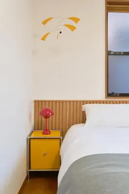 a bedroom with a bed and a red lamp on a night stand at Yotsuya Lantern - Private 3 stories house for family in Tokyo