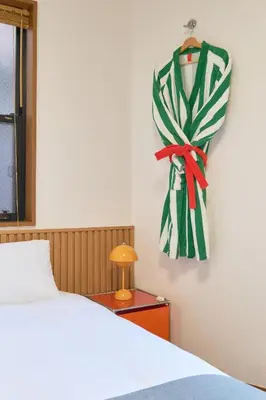 a bedroom with a bed and a towel hanging on a wall at Yotsuya Lantern - Private 3 stories house for family in Tokyo