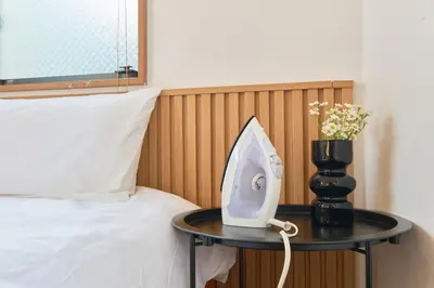 a table with a phone on it next to a bed at Yotsuya Lantern - Private 3 stories house for family in Tokyo