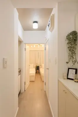 a hallway leading to a living room with white walls at Panda Stay\u65e9\u7a32\u7530\u99c5,\u65e9\u7a32\u7530\u5927\u5b66\u5f92\u6b691\u5206,\u9ad8\u7530\u99ac\u5834\u30a8\u30ea\u30a2\u8cb8\u5207\u90e8\u5c4b in Tokyo