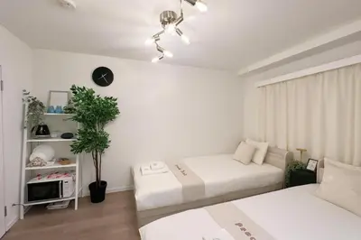 a living room with two beds and a tv at Panda Stay\u65e9\u7a32\u7530\u99c5,\u65e9\u7a32\u7530\u5927\u5b66\u5f92\u6b691\u5206,\u9ad8\u7530\u99ac\u5834\u30a8\u30ea\u30a2\u8cb8\u5207\u90e8\u5c4b in Tokyo