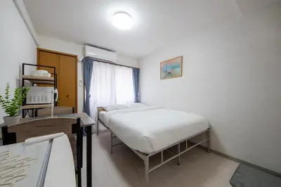 a bedroom with a bed and a desk and a window at CraftFlat Numabukuro 306, uphill residence in Tokyo