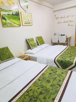 two beds in a room with a table and chairs at Shinjuku Downtown\u65b0\u5bbf in Tokyo