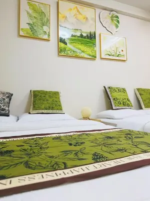 two beds in a room with paintings on the wall at Shinjuku Downtown\u65b0\u5bbf in Tokyo
