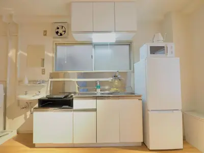 a white kitchen with a sink and a refrigerator at Chitose Corp in Tokyo