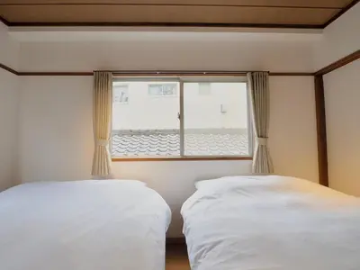 two beds in a room with a window at Chitose Corp in Tokyo