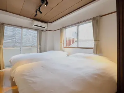 two white beds in a room with a window at Chitose Corp in Tokyo