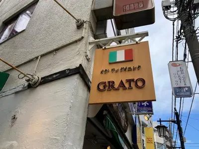 a sign for a grato restaurant on the side of a building at Chitose Corp in Tokyo
