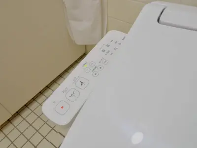a remote control on a toilet in a bathroom at Chitose Corp in Tokyo