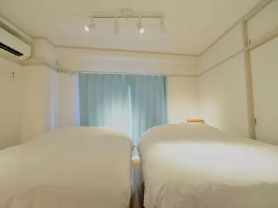 two white beds in a room with a window at Chitose Corp in Tokyo