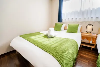 a bedroom with two beds and a window at 202 Room, a 6-minute walk from Tokyo Koiwa Station Direct connected to Shinjuku and Akihabara Stations Comfortable one-bedroom apartment with separate wet and dry areas in Tokyo