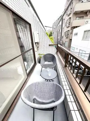 a balcony with two chairs and a table at Asakusa Sakura-3F in Tokyo