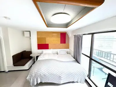 a bedroom with a bed and a couch and a window at Asakusa Sakura-3F in Tokyo